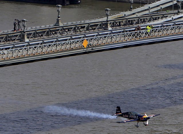 Peter Besenyei of Hungary flies his airplane under the Chain Bridge during an air show in Budapest, Hungary, May 1, 2015. (Photo by Bernadett Szabo/Reuters)
