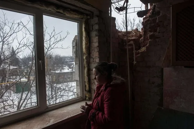 Olga Duzhikova looks through the window of her flat damaged by shelling in Avdiivka, Ukraine, Saturday, February 4, 2017. Fighting in eastern Ukraine sharply escalated this week. Ukraine's military said several soldiers were killed over the past day in shelling in eastern Ukraine, where fighting has escalated over the past week. (Photo by Evgeniy Maloletka/AP Photo)