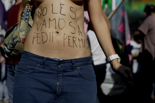A woman with the text written in Spanish on her torso “I will not ask for permission”, protests during a bare-breasted demonstration in Buenos Aires, Argentina, Tuesday, February 7, 2017. People took to the streets to protested after police threatened several weeks ago to detain several women sunbathing topless at a beach in Argentina. (Photo by Natacha Pisarenko/AP Photo)