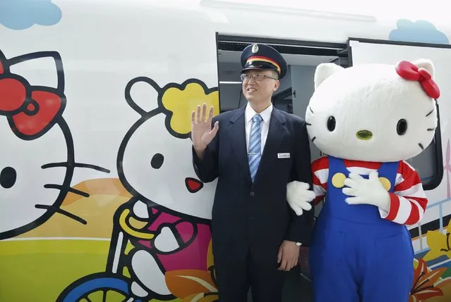 A performer dressed as Hello Kitty, poses with a conductor next to a Hello Kitty-themed Taroko Express train in Taipei, Taiwan March 21, 2016. (Photo by Tyrone Siu/Reuters)