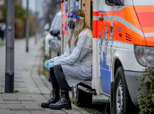 A medical worker waits for a child to get ready for a rapid test in a mobile Corona test van in Frankfurt, Germany, Monday, November 15, 2021. The numbers of Corona infections have been rising again in Germany. (Photo by Michael Probst/AP Photo)