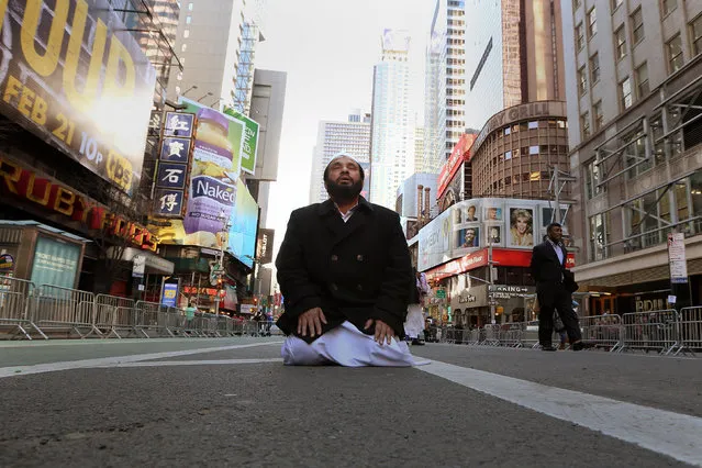 A Muslim man kneels on Broadway Ave. as he takes part in afternoon prayers during an “I am Muslim Too” rally in Times Square, Manhattan, New York, U.S. February 19, 2017. (Photo by Carlo Allegri/Reuters)