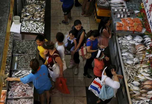 People shop for fish at a wet market in Singapore March 23, 2016. (Photo by Edgar Su/Reuters)