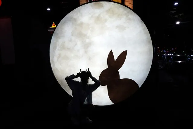 A Chinese tourist Niu Jiayi poses for a picture near a light sculpture for the Year of the Rabbit in Bangkok, Thailand on January 20, 2023. The expected resumption of group tours from China is likely to bring far more visitors. (Photo by Sakchai Lalit/AP Photo)