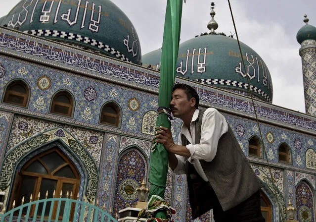 An Afghan Shiite man kisses the holy mace for blessings at the Karti Sakhi shrine in Kabul, Afghanistan, Tuesday, October 29, 2013. Afghan Muslim Sufi's, a mystical form of Islam, visit shrines daily and offer prayers. During the Taliban's rule, Sufi's a minority in Afghanistan were suppressed, but since the end of their rule, they have regained their place and are able to practice Sufism freely. (Photo by Rahmat Gul/AP Photo)