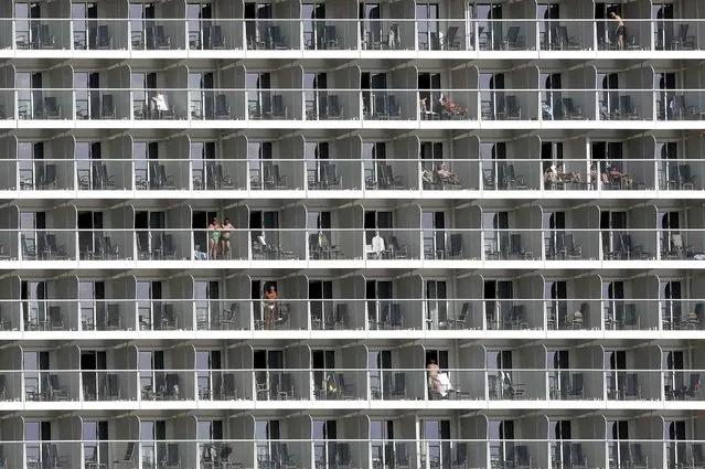 Vacationers are seen on cabin balconies of the 347-meter Quantum of the Seas cruise ship docked at the port of Piraeus near Athens, Monday, May 18, 2015. Greece's cash strapped government is examining ways to improve tax collection from the country's key tourism sector as it struggles to continue payments to bailout lenders. (Photo by Petros Giannakouris/AP Photo)