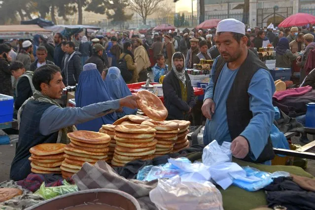 A vendor sells bread at a street market in the Pul-e Khishti area of Kabul on December 2, 2021. (Photo by Ahmad Sahel Arman/AFP Photo)