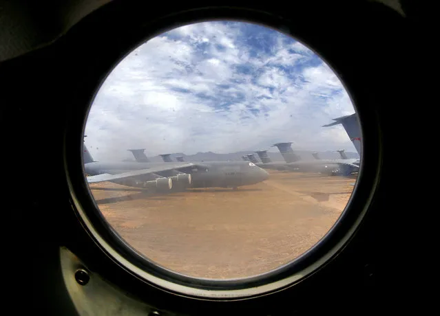 A field of Lockheed C-5 Galaxy cargo jets are seen through a window from another C-5 at the 309th Aerospace Maintenance and Regeneration Group boneyard at Davis-Monthan Air Force Base in Tucson, Ariz. on Thursday, May 21, 2015. The C-5A Galaxy is the largest aircraft in the U.S. armed services. The C-5 has a wingspan of over 222 feet and stands over 65 feet high has been used by the Air Force continually since 1969. (Photo by Matt York/AP Photo)