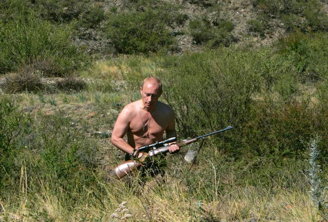 Russia's President Vladimir Putin walks with a rifle in southern Siberia's Tuva region August 15, 2007. (Photo by Reuters/RIA Novosti)