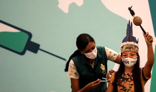 Vanderlecia Ortega dos Santos, or Vanda, from the Witoto indigenous tribe, receives the Sinovac coronavirus disease (COVID-19) vaccine in Manaus, Brazil on January 18, 2021. (Photo by Bruno Kelly/Reuters)