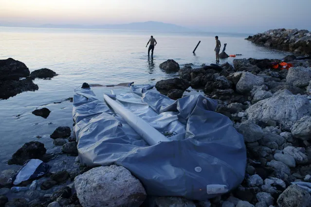 Syrian migrants look for their missing passports in the sea after their arrival on a small boat, foreground, from a Turkish coast to the Greek island of Lesvos in Mytilene, on Wednesday, June 17, 2015. Around 100,000 migrants have entered Europe so far this year as Italy and Greece have borne the brunt of the surge with many more migrants expected to arrive from June through to September. (AP Photo/Thanassis Stavrakis)