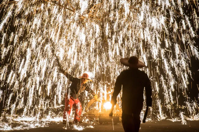 Artists perform with molten metal to create sparks like fireworks during the “Molten Metal Sparks (Datiehua)” show, near Badaling Great Wall, in Yanqing district of Beijing, China, 07 February 2019. “Datiehua” is an ancient Chinese firework show where artists perform in different ways with molten metal to create sparks like fireworks. When metal is melted down it has a temperature of 1600 degrees Celsius. Its typical shows include Jing Tao Hai Lang (raging waves), Huo Shu Jin Hua (fiery trees and gold flowers), Er Long Xi Zhu (two dragons playing with a pearl), Kong Zhong Li Huo (thunderbolt) and other. The performance has become popular in recent years and thousands of people watch it every day during the Spring Festival period. The Chinese Lunar New Year, the Year of the Pig, began on 05 February 2019. (Photo by Roman Pilipey/EPA/EFE)