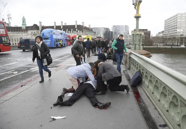 Injured people are assisted after an incident on Westminster Bridge in London, Britain on Wednesday, March 22, 2017. (Photo by Toby Melville/Reuters)