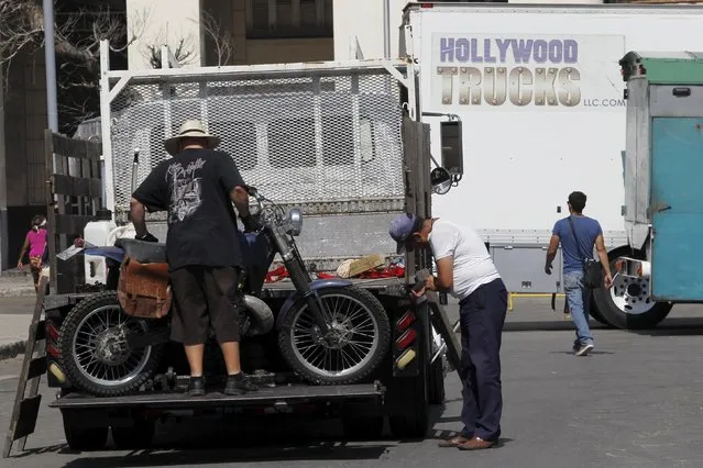 Members of a production team unload a motorbike from a truck during the filming of the movie “Fast and Furious 8” in Havana, Cuba, April 22, 2016. (Photo by Reuters/Stringer)