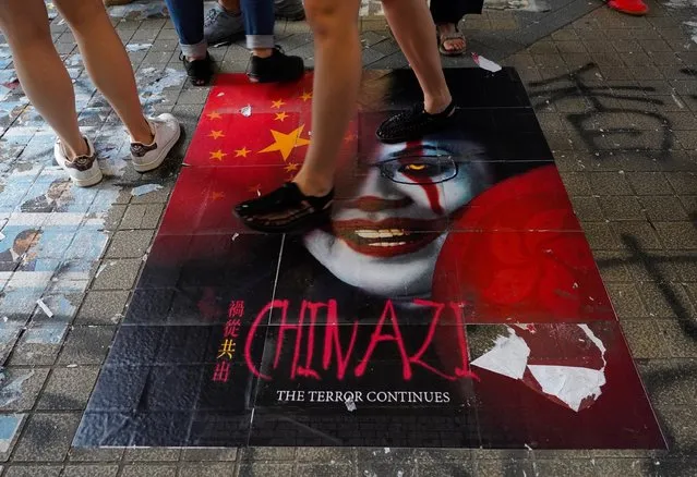 Pedestrians step on a caricature of Hong Kong Chief Executive Carrie Lam, part of a newly created Lennon Wall in Hong Kong, Saturday, September 28, 2019. Hong Kong activists first created their own Lennon Wall during the 2014 protests, covering a wall with a vibrant Post-it notes calling for democratic reform. Five years later, protestors have gathered to create impromptu Lennon Walls across Hong Kong island. (Photo by Vincent Yu/AP Photo)