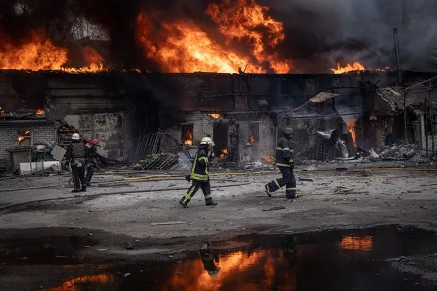 Firefighters work to extinguish a fire at a warehouse after it was  hit by Russian shelling on March 28, 2022 in Kharkiv, Ukraine. More than half Kharkiv's 1.4 million people have fled the city since Russia's invasion on Feb. 24, which was followed by weeks of intense bombardment. Russian forces remain to the city's north and east, but have met heavy resistance from Ukrainian troops here. (Photo by Chris McGrath/Getty Images)