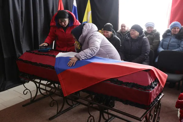 People attend a farewell ceremony for Sergei Sokolov, the 21 year-old serviceman who was killed during Russian military action in Ukraine, in the settlement of Zubkovo in Novosibirsk region on March 24, 2022. (Photo by Rostislav Netisov/AFP Photo)