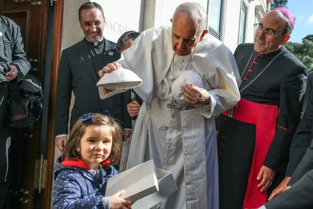 Pope Francis (C) accompanied by Leiria-Fatima Bishop Antonio Marto (R) changes skull-caps with a young child at the entrance of the Our Lady Rosario Cathedral at the Fatima Sanctuary, in Leiria, Portugal, 13 May 2017. Pope Francis is in visiting Fatima on 12 and 13 May on the 100th anniversary of the apparent appearances of the Virgin Mary to three shepherd children in 1917. (Photo by Paulo Cunha/EPA)