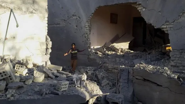 A man navigates the rubble of a destroyed home after a bombing in Fallujah, 40 miles (65 kilometers) west of Baghdad, Iraq, Thursday, May 26, 2016. The Islamic State group is preventing people from fleeing Fallujah amid a military operation to recapture the city west of Baghdad, a local Iraqi official and aid groups said on Wednesday. (Photo by AP Photo)