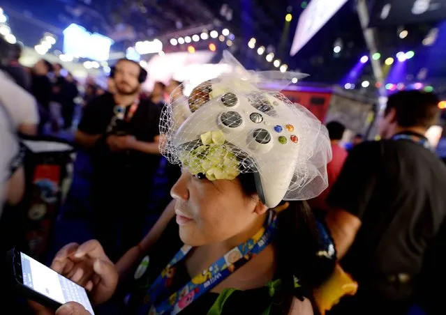 Microsoft employee Sammy Ng wears an Xbox game controller as a fascinator as she watches a trailer of the new multiplayer action game "Call of Duty: Advanced Warfare" in the Activision booth at the 2014 Electronic Entertainment Expo, known as E3, in Los Angeles, June 10, 2014.  REUTERS/Kevork Djansezian