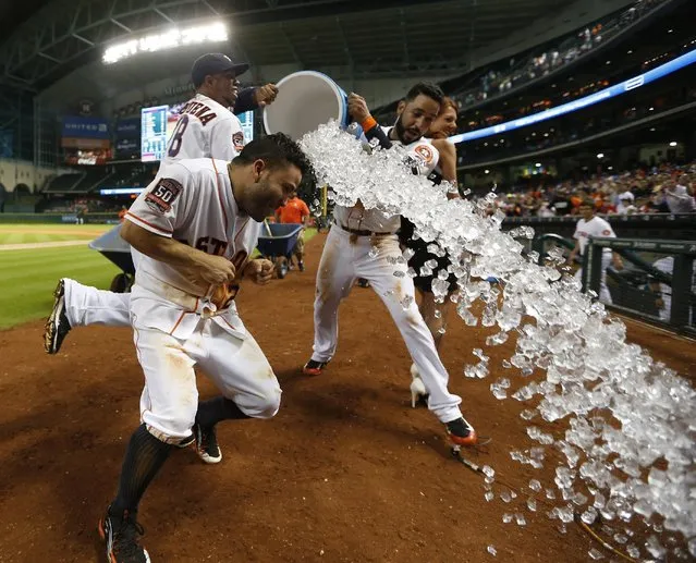 Houston Astros' Jose Altuve (27) gets dunked by Luis Valbuena (18) and Marwin Gonzalez, right, after hitting the game-winning home run in the ninth inning of a baseball game against the Boston Red Sox at Minute Maid Park on Thursday, July 23, 2015, in Houston. The Astros won 5-4. (Photo by Karen Warren/Houston Chronicle via AP Photo)