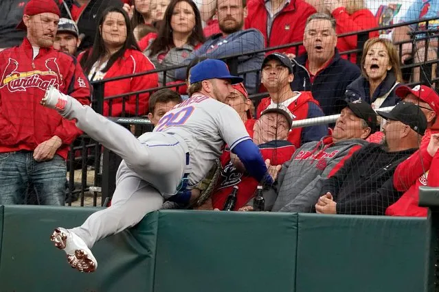 New York Mets first baseman Pete Alonso falls against netting as he catches a foul ball by St. Louis Cardinals' Paul Goldschmidt for an out during the first inning of a baseball game Monday, April 25, 2022, in St. Louis. (Photo by Jeff Roberson/AP Photo)
