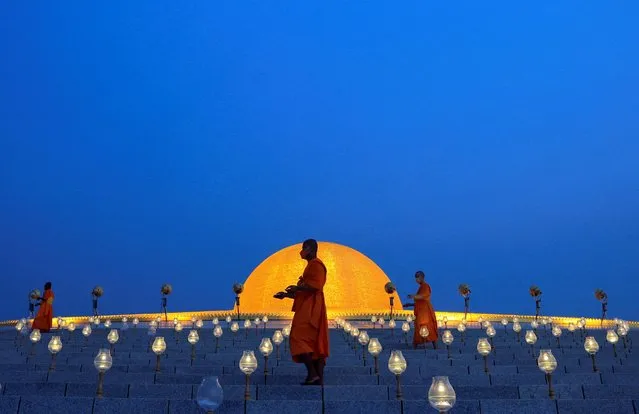 Buddhist monks turn on the LED lights to form an image of the Lord Buddha, as people observe Vesak Day, an annual celebration of Buddha's birth, enlightenment and death, at Dhammakaya Temple, Pathum Thani, near Bangkok, Thailand on May 15, 2022. (Photo by Soe Zeya Tun/Reuters)