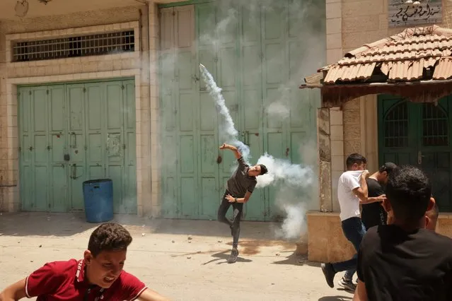 Palestinians clash with Israeli security forces during the funeral of Ghofran Warasnah, killed after she approached an Israeli soldier with a knife, in Al-Aroub refugee camp north the West Bank city of Hebron, on June 1, 2022. A statement from the army said the “attempted stabbing” took place near Al Aroub camp, north of the city of Hebron. (Photo by Hazem Bader/AFP Photo)