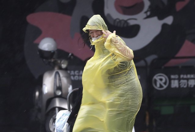 A woman struggles with winds generated by Typhoon Krathon in Kaohsiung, Southern Taiwan, Wednesday, October 2, 2024. (Photo by Chiang Ying-ying/AP Photo)