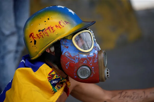 A demonstrator looks on while clashing with riot security forces during a rally against Venezuela's President Nicolas Maduro's government in Caracas, Venezuela, August 12, 2017. (Photo by Andres Martinez Casares/Reuters)