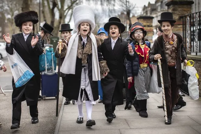 Jewish children dance down the street during the annual Jewish holiday of Purim on March 10, 2020 in London, England. Purim is celebrated by Jewish communities around the world with parades and costume parties. Purim commemorates the defeat of Haman, the advisor to the Persian king, and his plot to massacre the Jewish people, 2,500 years ago, as recorded in the biblical book of Esther. (Photo by Dan Kitwood/Getty Images)