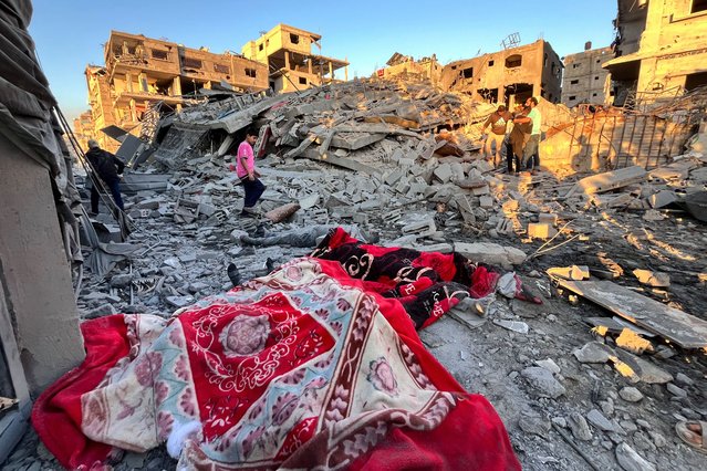 The bodies of victims recovered from the rubble of a building are covered with blankets as people continue their search, after an overnight Israeli strike that reportedly killed a local journalist and tens of others in the northern Gaza Strip on November 17, 2024. (Photo by AFP Photo/Stringer)