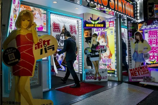 A man enters an adult amusement establishment in Shinjuku's nightlife district of Kabukicho in Tokyo, August 27, 2015. (Photo by Thomas Peter/Reuters)