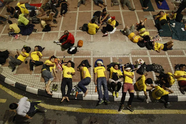 Activists from the Coalition for Clean and Fair Elections (BERSIH) sleep overnight along the pavement during a rally in Kuala Lumpur, Malaysia, Sunday, August 30, 2015. Tens of thousands of Malaysians wearing yellow T-shirts and blowing horns defiantly held a major rally in the capital Saturday to demand the resignation of embattled Prime Minister Najib Razak. (Photo by Joshua Paul/AP Photo)