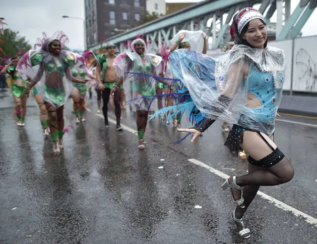 Performers in costume perform in the rain during the parade on the second day of the Notting Hill Carnival in west London on August 31, 2015. Nearly one million people are expected by the organizers Sunday and Monday in the streets of west London's Notting Hill to celebrate Caribbean culture at a carnival considered the largest street demonstration in Europe.  (Photo by Leon Neal/AFP Photo)