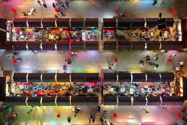 This aerial photo taken on April 2, 2020 shows people visiting a night market in Shenyang in China's northeastern Liaoning province. (Photo by AFP Photo/China Stringer Network)