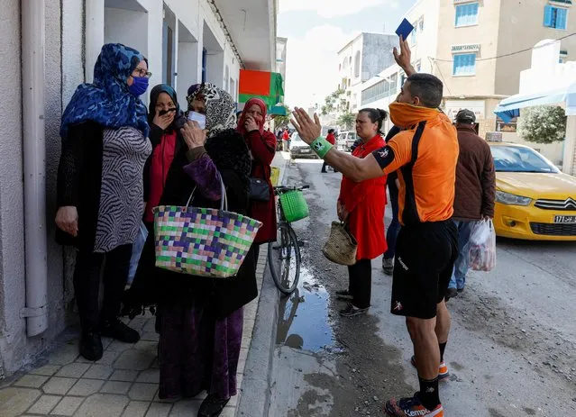 Abdelhak Etlili, a 19-year-old handball referee, issues a blue card for women gathered outside a shop and violating social distancing rules, amid concerns over the coronavirus disease (COVID-19), at the coastal town of Nabeul, Tunisia, April 23, 2020. (Photo by Zoubeir Souissi/Reuters)