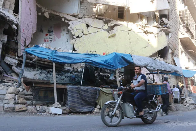 A man rides a motorcycle past merchandise stalls in Aleppo's rebel-controlled Bustan al-Qasr neighbourhood during a siege by Syrian pro-government forces that cut the supply lines into opposition-held areas of the city, Syria August 5, 2016. (Photo by Abdalrhman Ismail/Reuters)