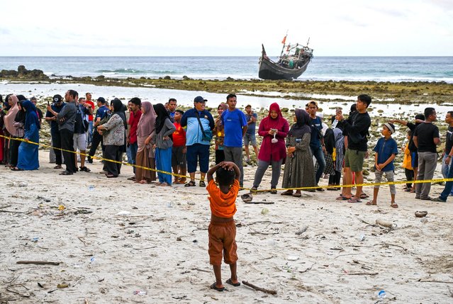 A Rohingya refugee child (C) is seen at a beach on Sabang island, Aceh province on December 2, 2023. More than 100 Rohingya refugees, including women and children, landed in Indonesia's westernmost province on December 2, officials said, but locals threatened to push them back to sea. (Photo by Chaideer Mahyuddin/AFP Photo)