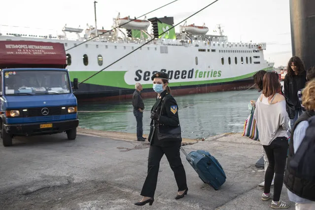 Passengers wearing face masks to curb the spread of the coronavirus disembark a ferry from Crete at the Piraeus port near Athens, on Monday, May 25, 2020. Greece restarted Monday regular ferry services to the islands as the country accelerated efforts to salvage its tourism season. (Photo by Petros Giannakouris/AP Photo)
