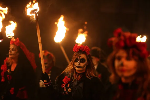 Revellers parade through the streets of Lewes in Sussex, southern England, on November 4, 2017, during the traditional Bonfire Night celebrations Thousands of people attend the parade through the narrow streets until the evening comes to an end with the burning of an effigy, or “guy”, usually representing Guy Fawkes, who died in 1605 after an unsuccessful attempt to blow up The Houses of Parliament. (Photo by Daniel Leal-Olivas/AFP Photo)