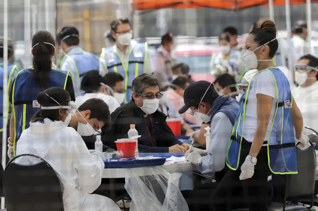 Health workers check Volkswagen employees before the reopening of the automotive sector as the spread of the coronavirus disease (COVID-19) continues, in Puebla, Mexico on June 16, 2020. (Photo by Imelda Medina/Reuters)