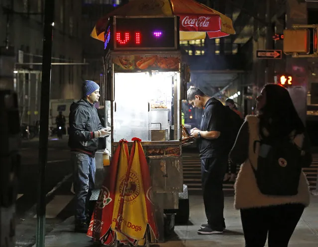 Waeld Naama, left, an Egyptian immigrant living in the United States for the past seven years, sells hot food from a cart across the street from Saint Peter's Roman Catholic Church and only one block from the World Trade Center, Wednesday, November 1, 2017, in New York. Since September 11, 2001, the neighborhood around the World Trade Center has been transformed by new construction and washed over by a wave of tourism. But this week's bike path attack reminded those who live, work, study and visit here of latent fears that this neighborhood would once again find itself in the crosshairs. (Photo by Kathy Willens/AP Photo)