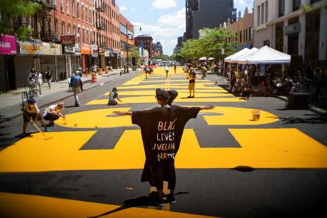 People paint a “Black Lives Matter” mural on the street as a protest against racial inequality in the aftermath of the death in Minneapolis police custody of George Floyd, in Brooklyn, New York City, U.S. June 14, 2020. (Photo by Eduardo Munoz/Reuters)