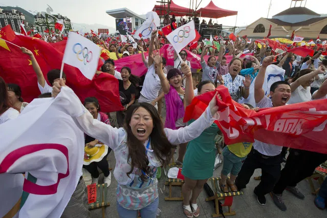 In this July 31, 2015, file photo, residents celebrate as Beijing is announced as the host city for the 2022 Winter Olympics at the ski resort region of Chongli where the Nordic skiing, ski jumping, and other outdoor Olympic events will be held in northern China's Hebei province. The next three Olympics are headed for relatively calmer ports of call in South Korea, Japan and China following the organizational drama surrounding the 2014 Winter Olympics in Russia and the just completed Summer Games in Brazil, but challenges remain, especially when it comes to finances and generating enthusiasm among home audiences. (Photo by Ng Han Guan/AP Photo)