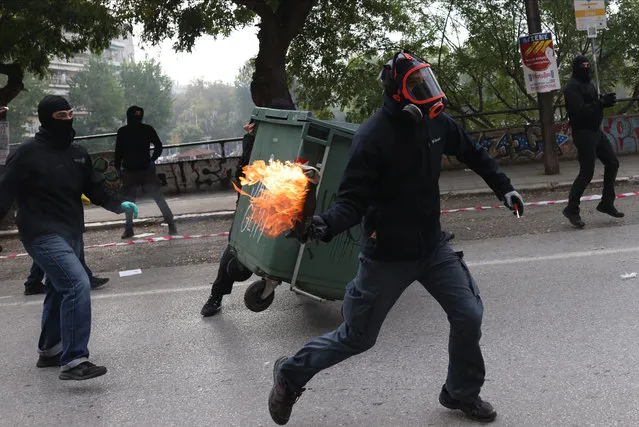 A protester hurls a molotov cocktail bomb towards riot police officers, during a demonstration in Thessaloniki, Greece, 09 November 2022. A 24-hour general strike, called by Greece's private and public sector unions over the energy and high cost of living, was set to shut down most services around the country. (Photo by Achilleas Chiras/EPA/EFE)