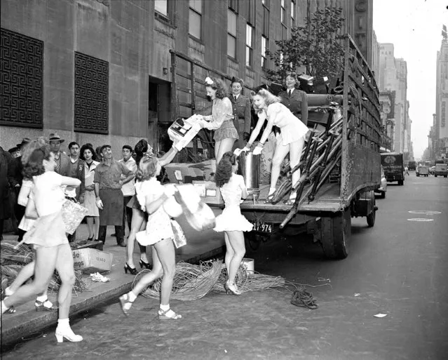 Chorus girls snappily load scrap metal onto a truck at one of the theaters at Radio City in New York, October 14, 1942. About 30,000 pounds of scrap metal were collected at the theatre in support of the war effort drive. (Photo by AP Photo)