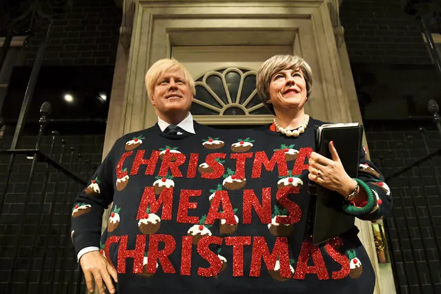 Madame Tussauds' wax figures of Britain's Prime Minister Theresa May and Foreign Secretary Boris Johnson wear one Christmas themed jumper between them and hold a sign, in London, December 13, 2017. (Photo by Clodagh Kilcoyne/Reuters)