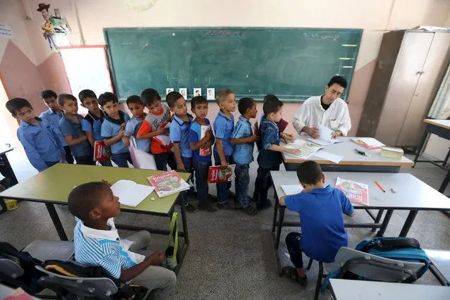 Mohammed Zurob marks an exercise for his first grade students during an English lesson inside a classroom at Taha Huseen elementary school in Rafah in the southern Gaza Strip September 28, 2015. (Photo by Ibraheem Abu Mustafa/Reuters)