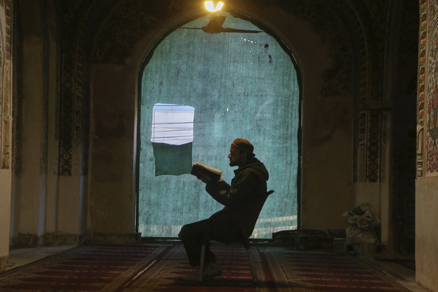 A Muslim reads verses of the Quran as he observes “Itikaf”, that requires staying in seclusion in a mosque spending most time in prayer and reading the Quran during the last 10 days of the Islamic fasting on month of Ramadan, at the historical Mahabat Khan Mosque, in Peshawar, Pakistan Friday, March 21, 2025. (Photo by Muhammad Sajjad/AP Photo)